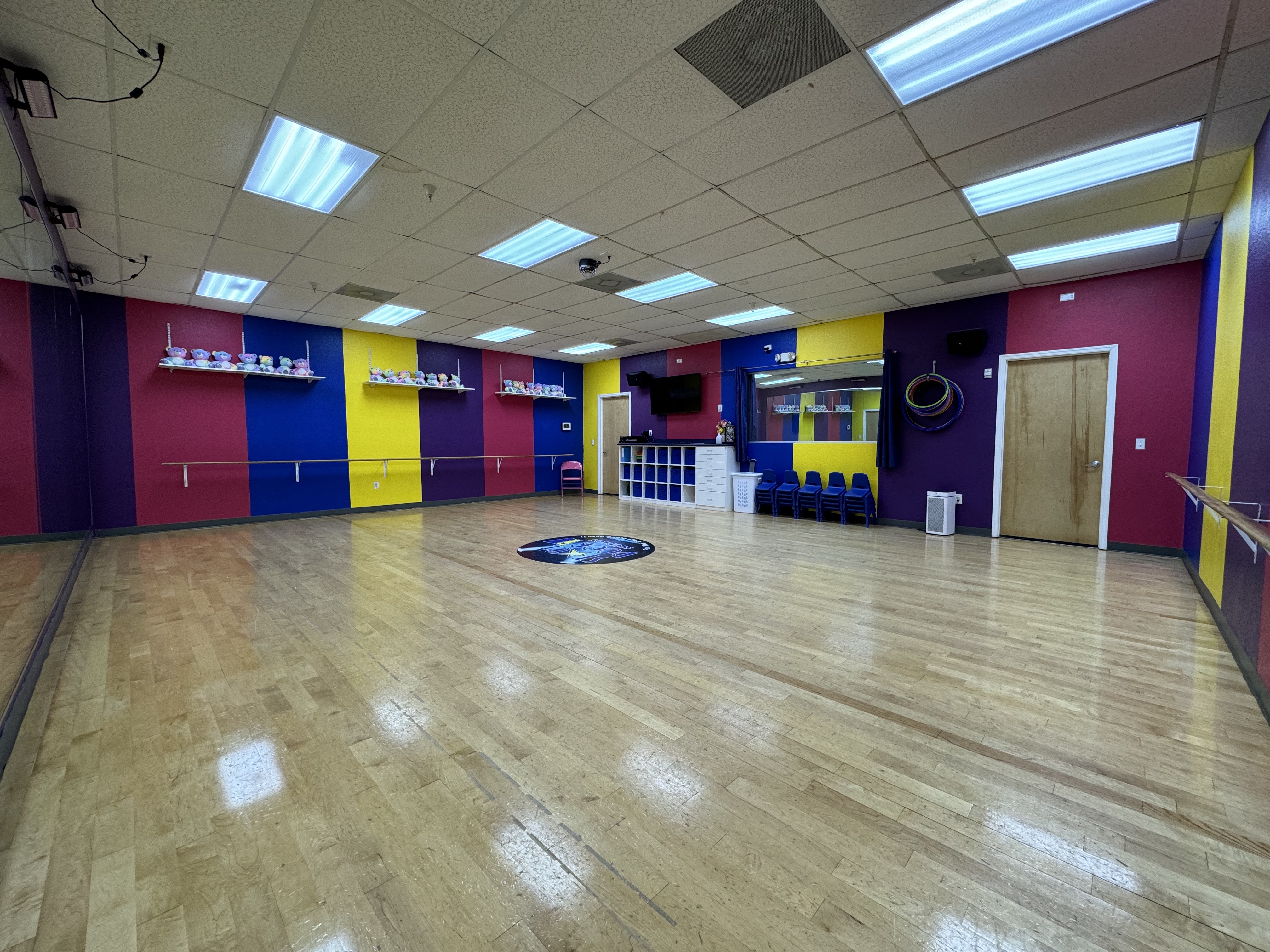 Bright, colorful Stage Door Studios dance studio interior with ballet barres and mirrors